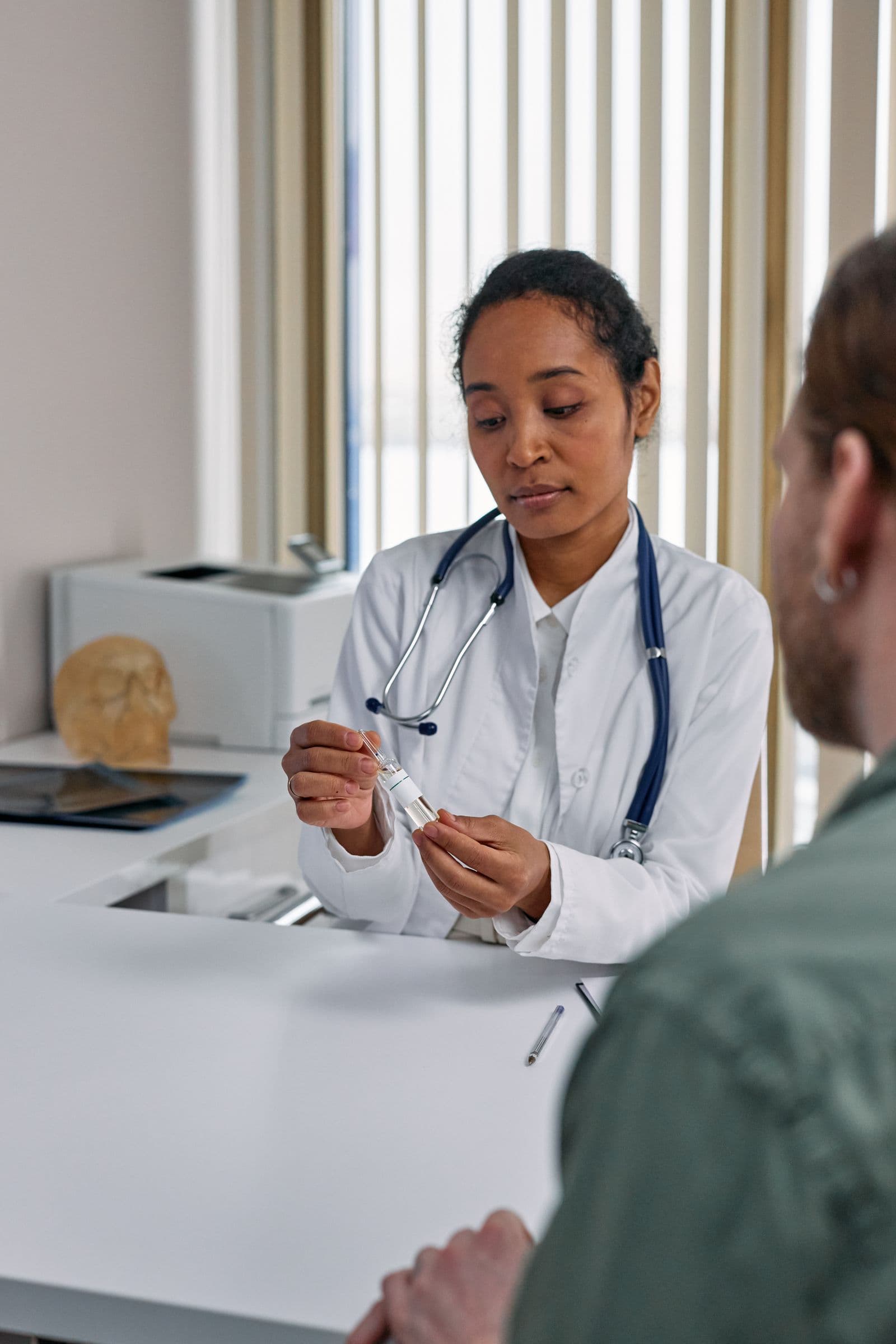 A doctor explaining medication to a patient across her desk