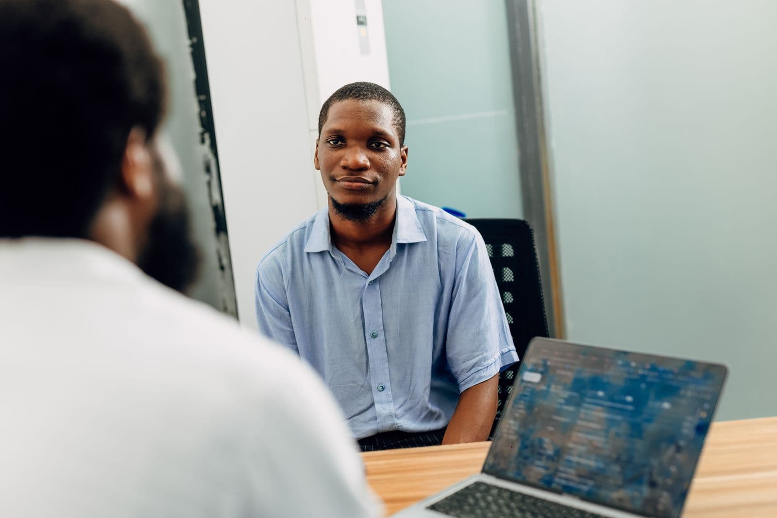 A candidate smiling during an interview in a modern Lagos office