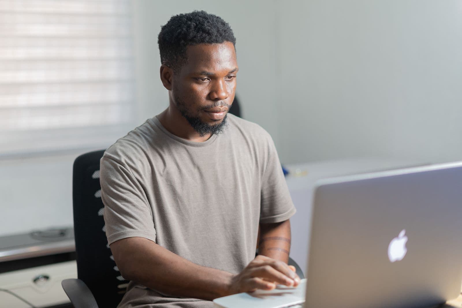 A man concentrating on his laptop at a desk