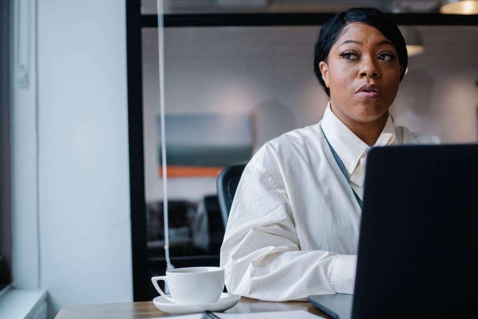 An HR lead thinking through a plan at her laptop