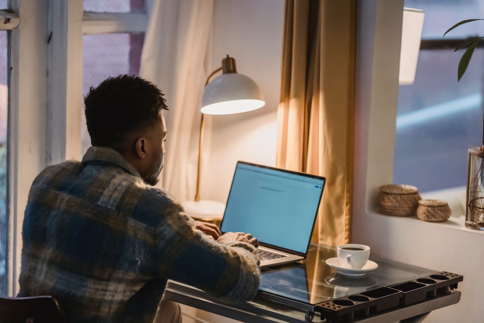 A man working on a laptop at home in the evening
